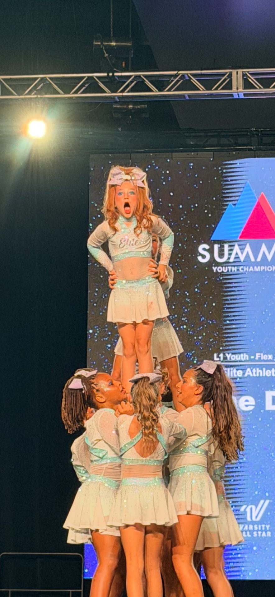 Elite Athletics cheerleaders supporting a flyer during a stunt at The Summit Youth Championship