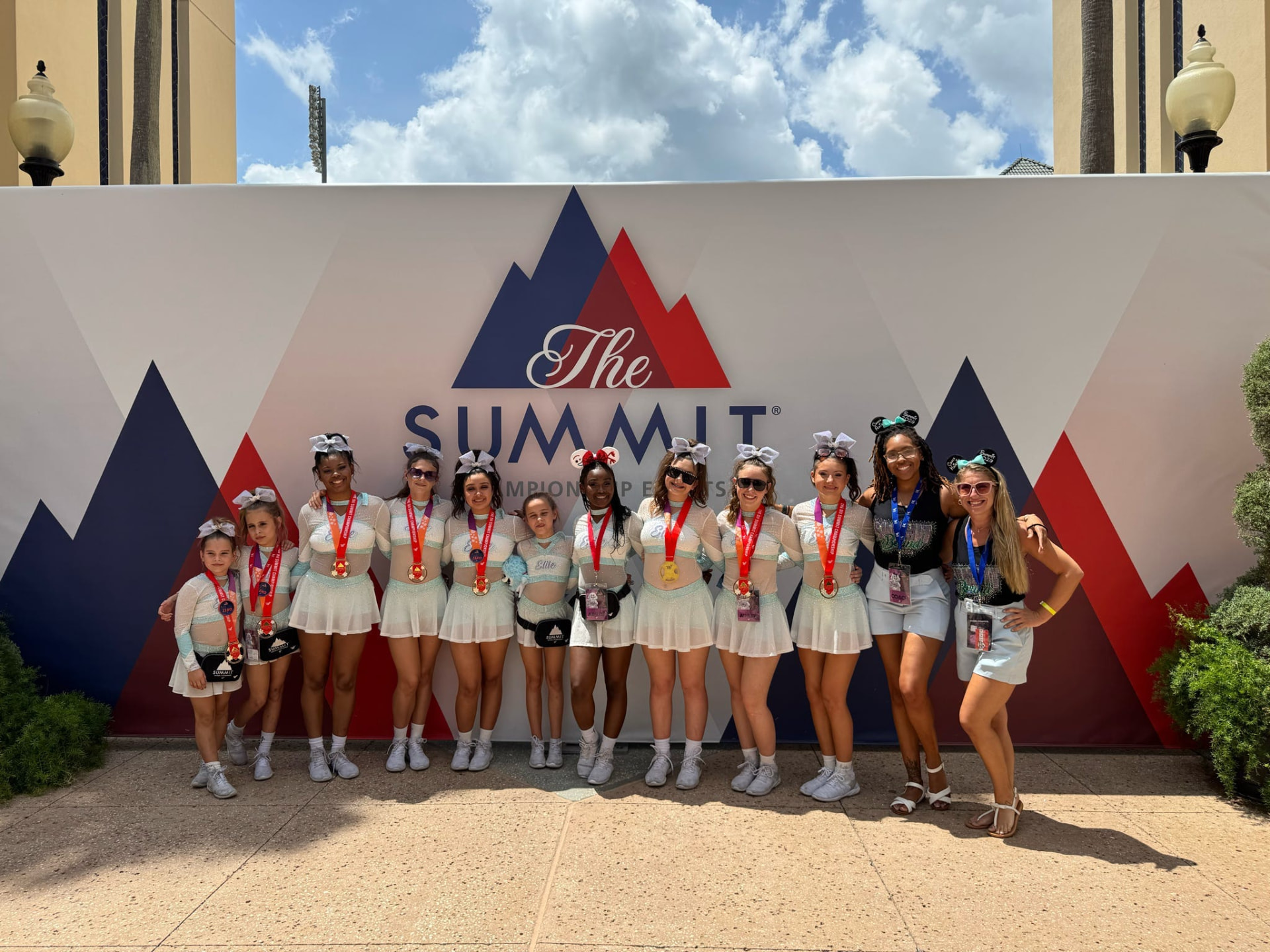 Elite Athletics athletes and supporters posing with medals at The Summit